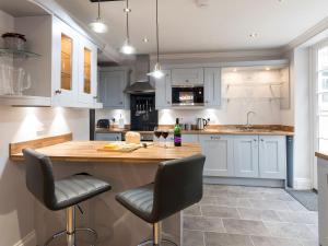 a kitchen with white cabinets and a wooden table and chairs at Beverley Minster House in Beverley