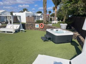 a backyard with a hot tub and a lawn at VILLAS NEW LANZASUITES PLUS in Playa Blanca