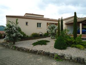 una casa con un jardín delante de ella en chambres d'hôtes du capimont en Hérépian