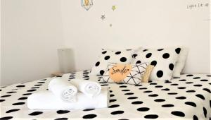 1 dormitorio con 1 cama en blanco y negro con toallas en D Wan Guest House, en Peniche