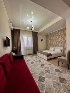 a large bedroom with a bed and a red carpet at Bastau Hotel in Almaty