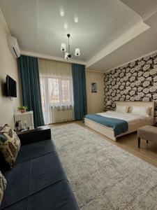 a large bedroom with a bed and a couch at Bastau Hotel in Almaty
