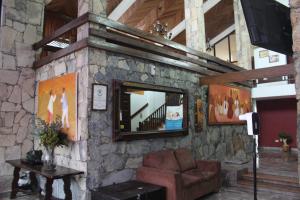 a living room with a stone wall with a mirror at Hotel Chipinque in Monterrey