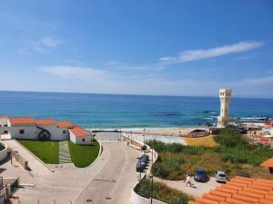 a view of a beach with a lighthouse and the ocean at Yellow Submarine on the seafront in Silveira