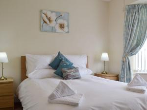 a bedroom with a white bed with pillows on it at Ashlea in Teversall