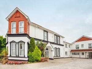 a large white and red house with a courtyard at Flower Pots House - Uk39782 in Paignton