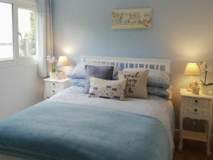 a bedroom with a bed with blue sheets and pillows at Trevone in St Merryn