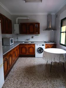 cocina con armarios de madera y horno de fogón blanco en Casa Don Julio, en Jimera de Líbar