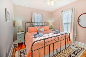 a bedroom with a bed with an orange bedspread at North Beach Cottage - Walk to Chesapeake Bay in North Beach