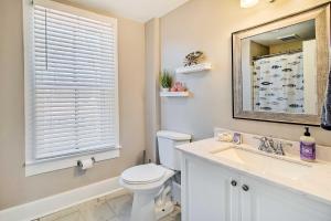 une salle de bain avec toilettes, lavabo et miroir dans l'établissement North Beach Cottage - Walk to Chesapeake Bay, à North Beach 26 autres photos
