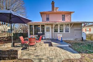 une maison avec des chaises et un parasol sur une terrasse dans l'établissement North Beach Cottage - Walk to Chesapeake Bay, à North Beach