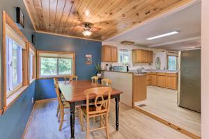 a kitchen and dining room with a wooden table and chairs at Harpers Ferry Cabin - Walk to Private Lake! in Harpers Ferry