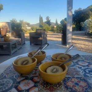 three bowls of food on a table with spoons at Podere Grandolfi B&B in Capoliveri