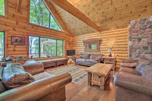 uma sala de estar com mobiliário de couro num chalé de madeira em Dreamy Cabin Steps to Thumb Lake Swim and Fish em Boyne Falls