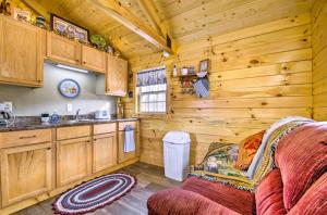 a kitchen with wooden cabinets and a couch in a cabin at Idyllic Florence Cabin with Grill and Creek Views in Florence