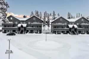 un gran edificio en la nieve con un estacionamiento en Tinden Apartments, en Hemsedal