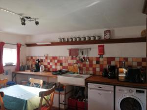 a small kitchen with a sink and a table at Gîte La maison rose in Hamois