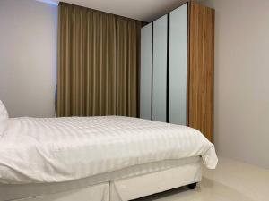 1 dormitorio con cama blanca y armario de madera en Minimalist Cozy Apartment by MESA, en Nagoya