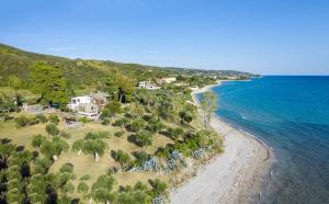 z góry widok na plażę z domami i ocean w obiekcie Malt Beachfront Villa w mieście Mola Kalyva