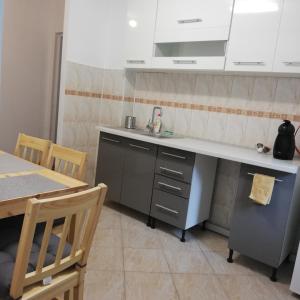 a kitchen with a sink and a table with chairs at Ruud Mall in Timişoara