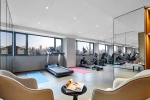 a gym with a treadmill and exercise equipment in a building at Holiday Inn Shanghai Huaxia, an IHG Hotel - overlooking city scenery at Sky View Restaurant in Shanghai