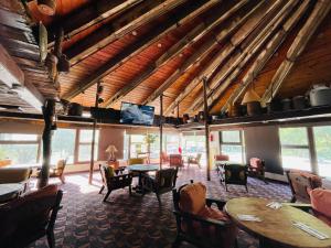 a dining room with tables and chairs and a flat screen tv at Hotel Chipinque in Monterrey