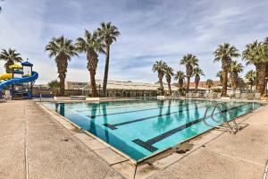 a swimming pool with a slide and palm trees at Beautiful St George Condo about 5 Mi to Downtown! in St. George