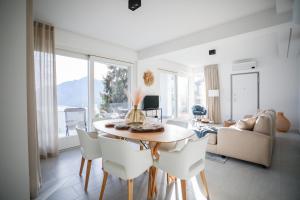 a white living room with a table and chairs at IseoLakeRental - Seliera in Solto Collina