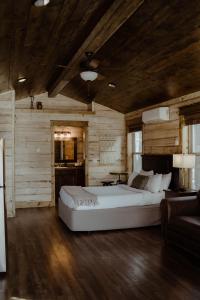 a bedroom with a large white bed and wooden walls at Teton Valley Resort in Victor
