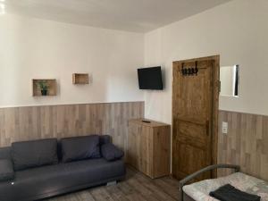 a living room with a couch and a wooden door at Ferienwohnung Funke F3 für Monteure in Apolda