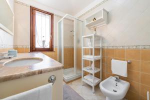 een badkamer met een wastafel, een toilet en een douche bij Attico il Mandorleto in Villasimius +15 foto's