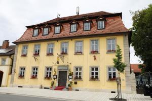 een geel gebouw met een rood dak bij Hotel Goldener Adler Garni in Hallstadt