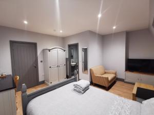 een slaapkamer met een bed, een tv en een stoel bij Shared house close to Liverpool city center & LFC/EFC in Liverpool