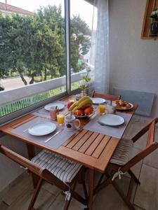 - une table en bois avec un petit-déjeuner composé de fruits et de jus dans l'établissement Sanary sur mer, Soleil et douceur I, à Sanary-sur-Mer