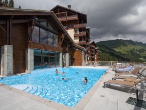 eine Gruppe von Personen in einem Schwimmbad neben einem Gebäude in der Unterkunft Appartement 3 pièces avec cheminée, accès pistes, piscine, spa, WIFI - Flaine Montsoleil - FR-1-425-140 in Flaine