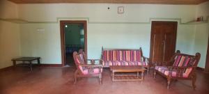 a room with three chairs and a table and a table and chairs at Aache Veedu Farm House in Jaffna