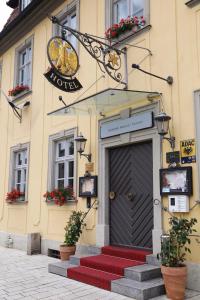 eine Tür zu einem Gebäude mit roten Stufen vorne in der Unterkunft Hotel Goldener Adler Garni in Hallstadt