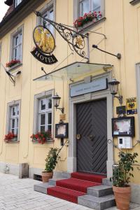 a door to a building with red steps in front at eXo Hotel Franka Bamberg - by NeVo Hotels in Hallstadt
