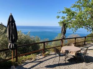 two umbrellas and a table and chairs on a patio at Villa Pietrafiore in Monterosso al Mare