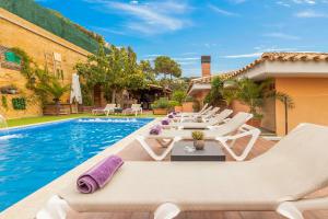 a pool with white lounge chairs and a swimming pool at Villa Origami in Lloret de Mar