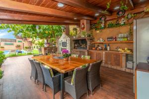 een buitenkeuken met een houten tafel en stoelen bij Villa Origami in Lloret de Mar
