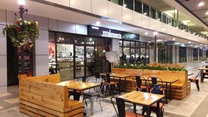 a restaurant with wooden tables and chairs in a mall at Vista Alam Studio in Shah Alam