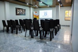 a conference room with black chairs and a projection screen at Hotel Brisas De Calima in Cali
