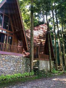une maison avec un mur en pierre et un balcon dans l'établissement Wonderful Citamiang by Anrha, à Puncak