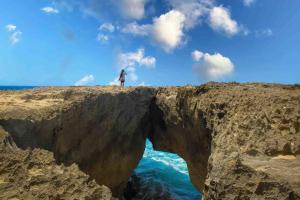 a person standing on the edge of a rock formation at Brisas de Isabela Cozy Glamper 1A in Isabela