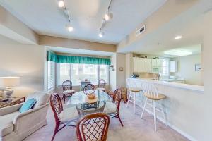a living room with a table and chairs and a kitchen at Tidewater Retreat in North Myrtle Beach