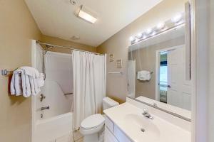 a bathroom with a sink and a toilet and a mirror at Tidewater Retreat in North Myrtle Beach