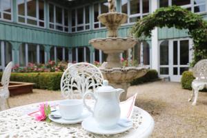 a table with a teapot and cups and saucers on it at eXo Hotel Franka Bamberg - by NeVo Hotels in Hallstadt