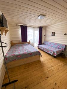 een slaapkamer met 2 bedden in een kamer met houten vloeren bij Royal Yablunytsya in Yablunytsia