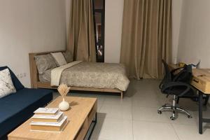 sala de estar con cama, escritorio y escritorio en luxury 1 BR studio in Sharjah, en Sharjah